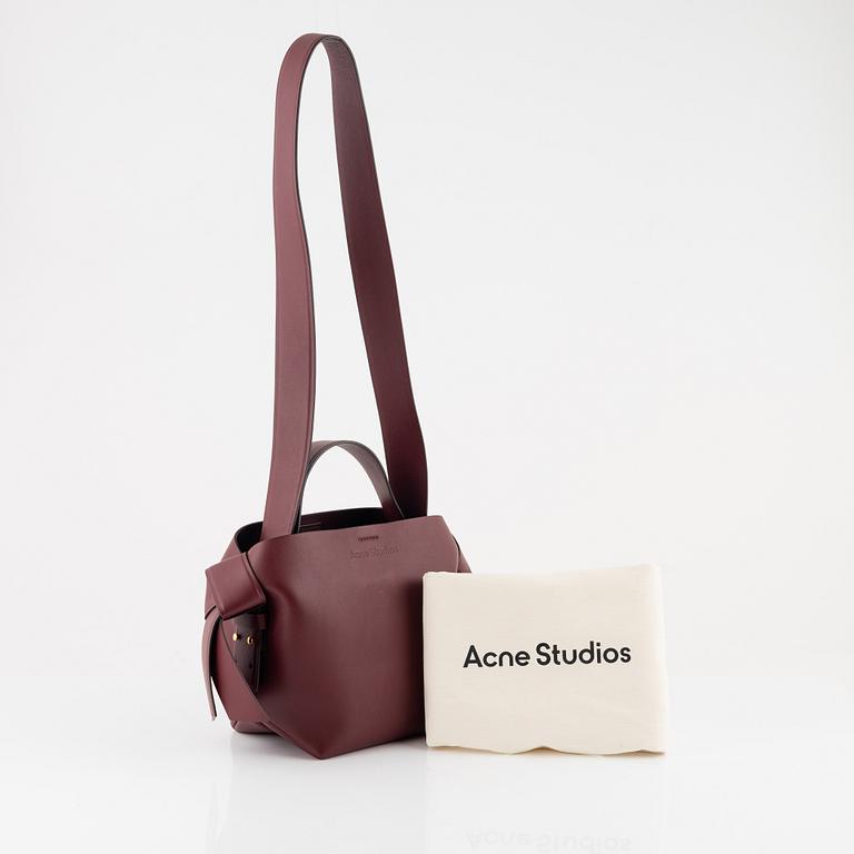 Acne Studios, a burgungy leather 'Musubi Mini' handbag.