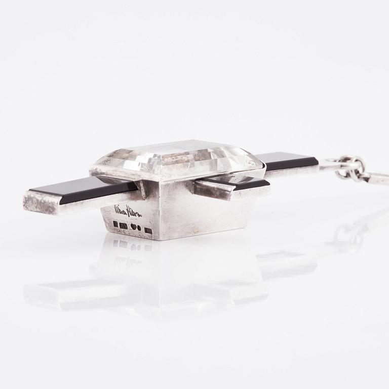 Wiwen Nilsson, hängsmycke i form av ett kors i sterlingsilver med fasettslipad bergkristall och onyx, Lund 1938.