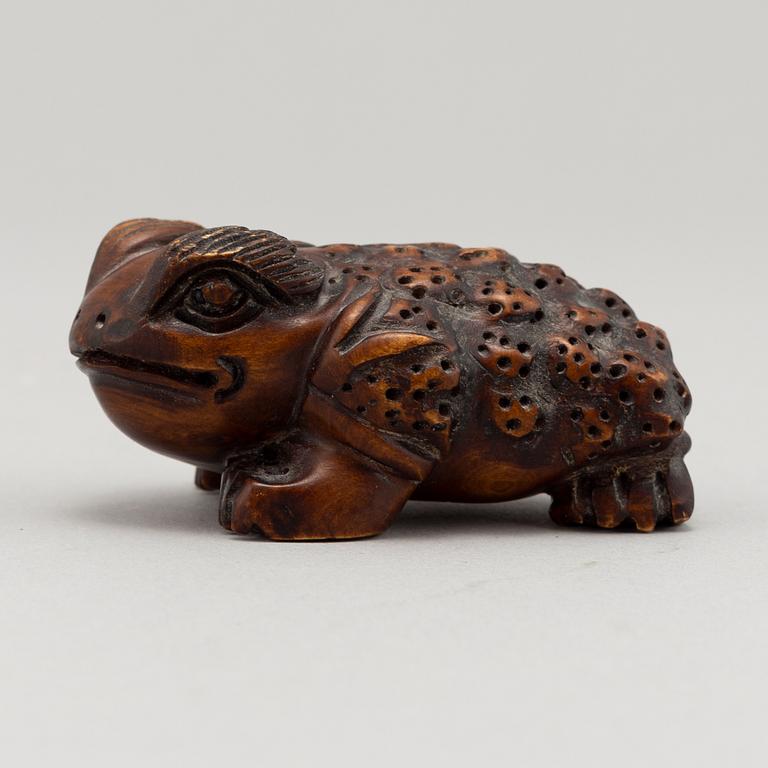 A carved wooden netsuke in the shape of a frog, 20th century.