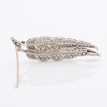 Brosch platina med runda briljantslipade diamanter samt smaragder.