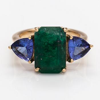 A 14K gold ring with tanzanites and a ca 5.80 ct emerald.