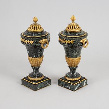 A pair of marble and gilt bronze decorative urns, Louis XVI-style, late 19th Century.