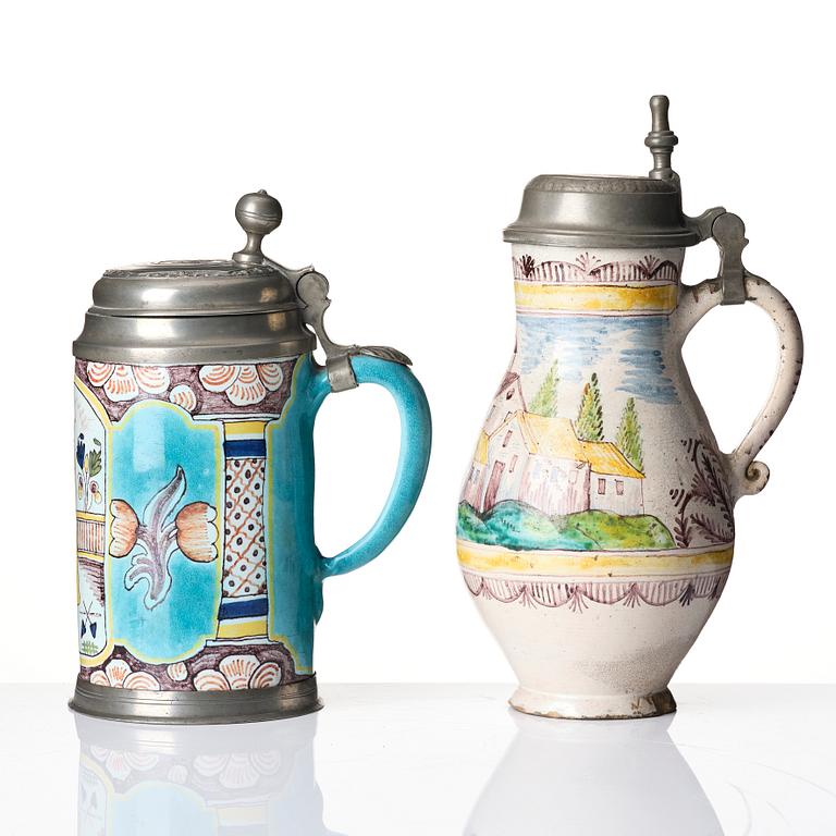 Two German faiance tankards with tin mountings, 18th century.
