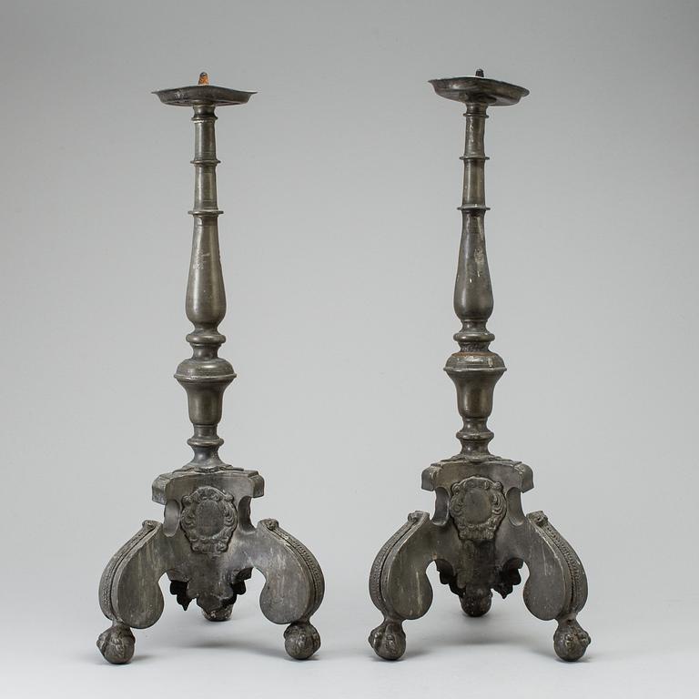 A pair of baroque pewter candlesticks, engraved date 1699.