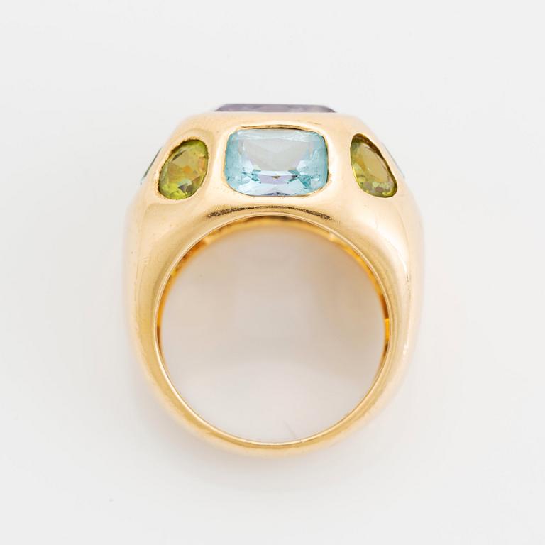 An 18K gold ring set with faceted amethyst, peridot and aquamarine.