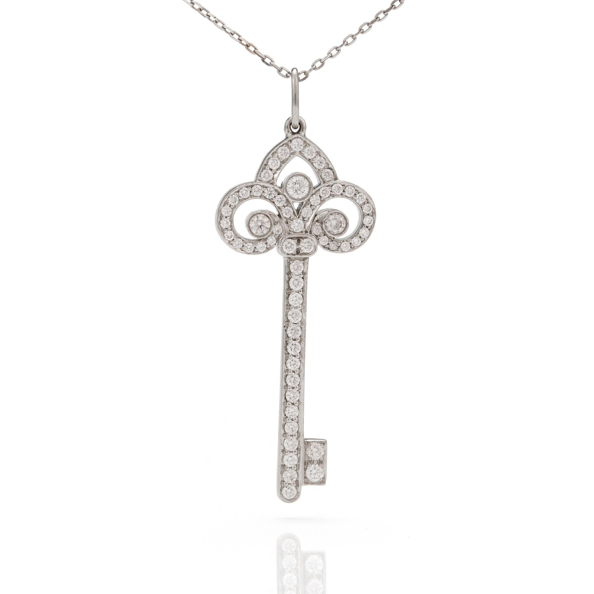 A 'Fleur de lis key' pendant set with round, brilliant-cut diamonds by Tiffany together with a chain.