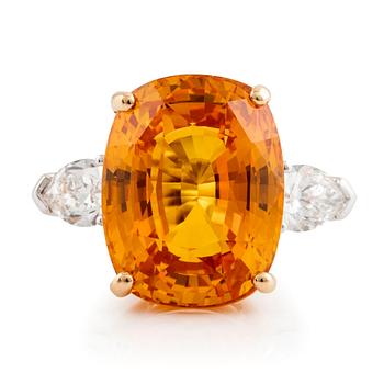 480. An 18K white gold ring set with a cushion shaped orange-yellow sapphire.