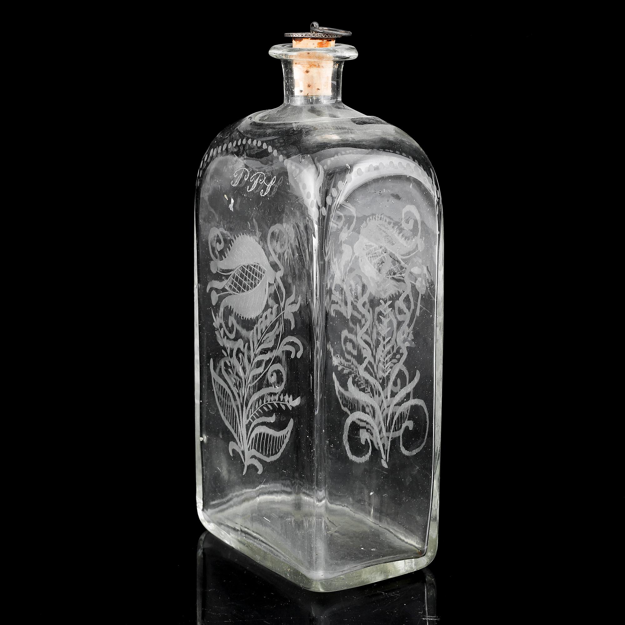 A glass bottle and three vodka glasses, 19th Century.