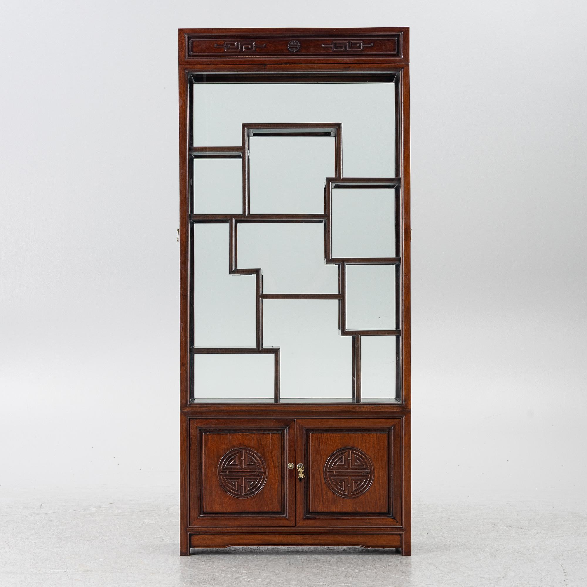 A Chinese display cabinet, wood and glass, later part of the 20th century.