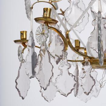 A near pair of rococo-style gilt brass and cut glass six-branch chandeliers, 19th century incorporating older elements.