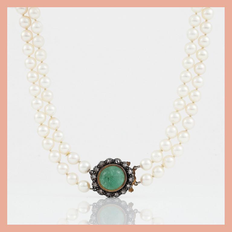 A two-strand cultured pearl necklace. Clasp with cabochon-cut emerald and rose-cut diamonds.