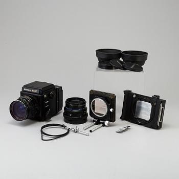 A black Mamiya RZ67 Pro Medium Format Camera Body with sekor z f = 110 mm 1:2.8 and sekor c f = 50 mm 1:4.5 lens.