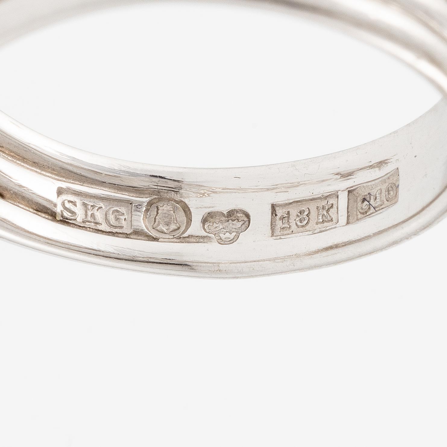 A ring in 18K white gold set with a round brilliant-cut diamond.