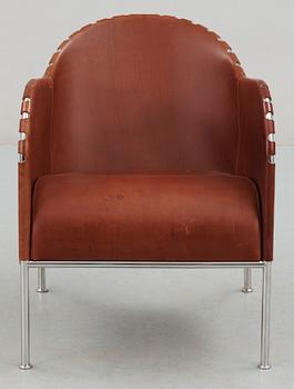 A Mats Theselius steel and brown leather easy chair.