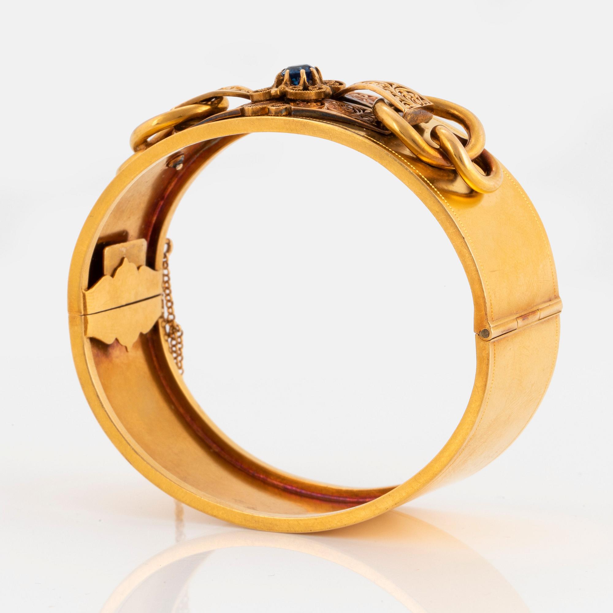 Armring 18K guld med en fasettslipad safir.