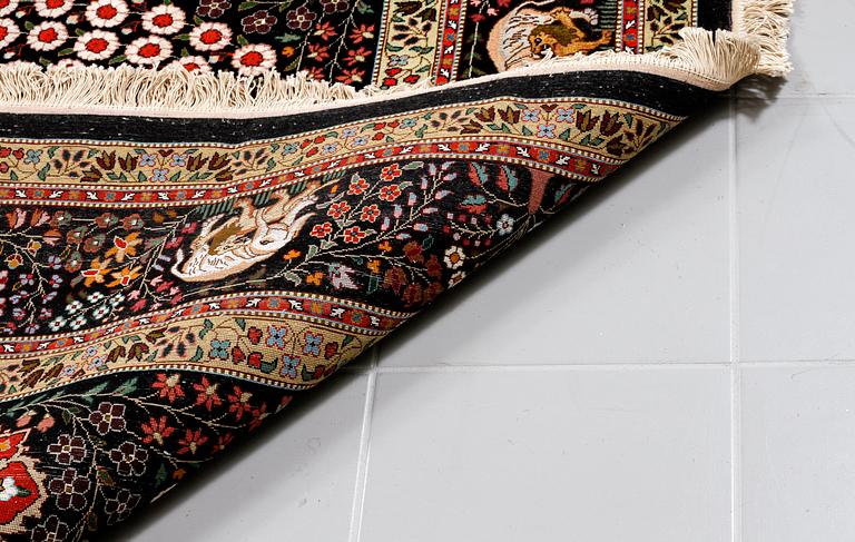 A Täbriz rug, part silk, signed, 255 x 172 cm.