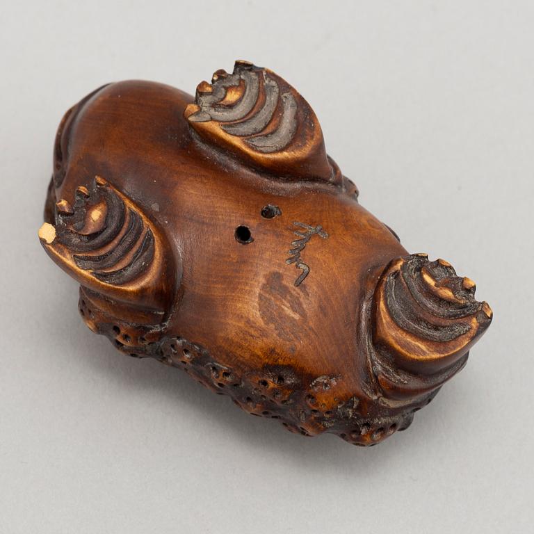 A carved wooden netsuke in the shape of a frog, 20th century.