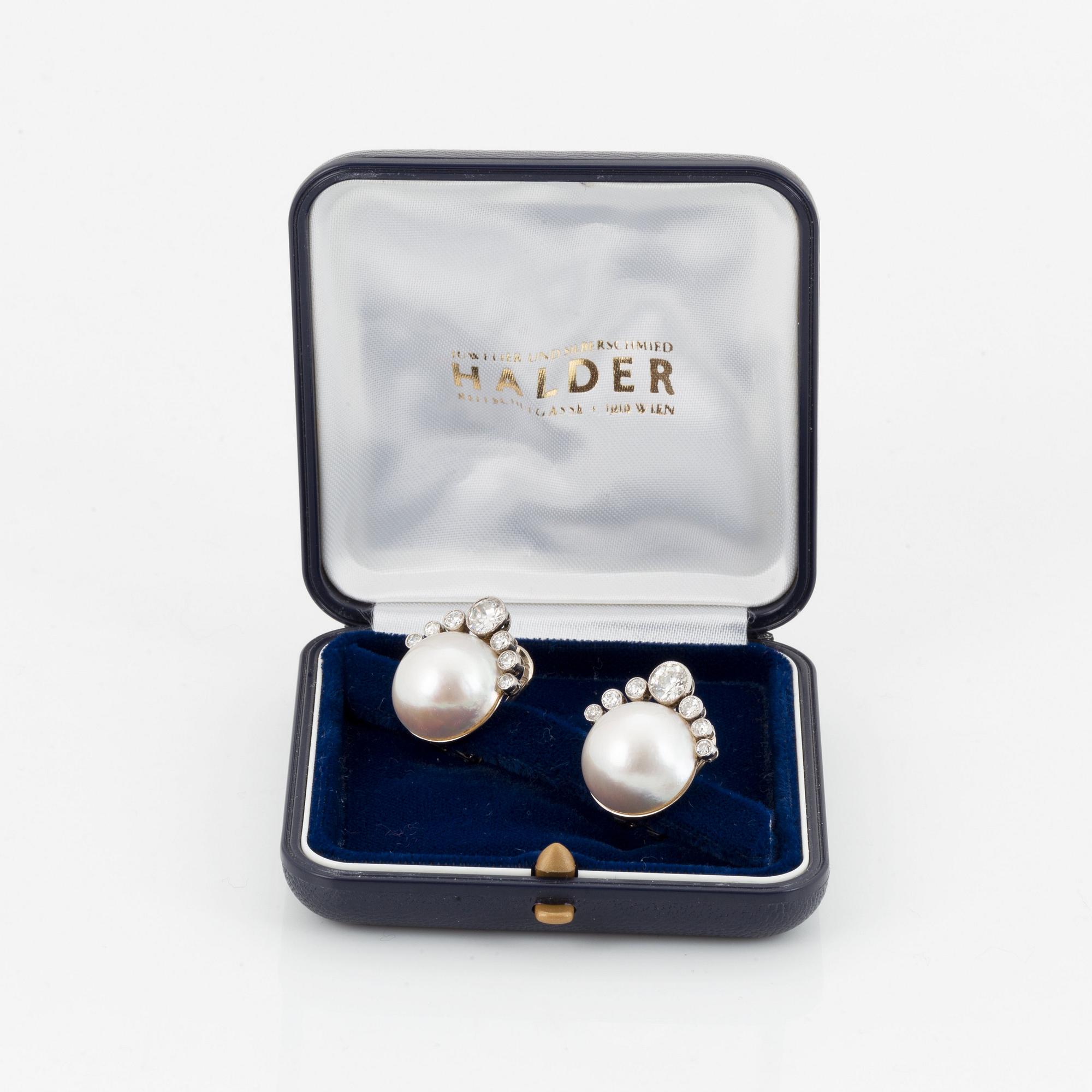 A pair of 18K white gold earrings set with mabe pearls and round brilliant-cut diamonds.