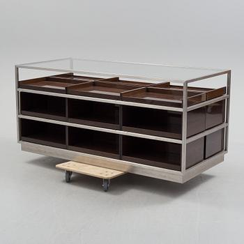 A modern glass and metal cabinet for shop use.