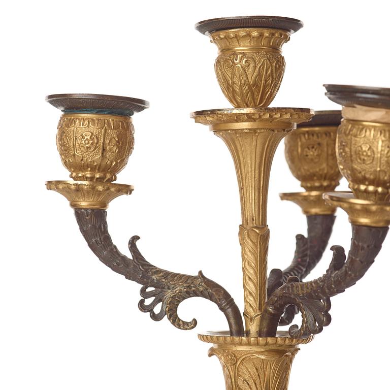 A pair of French Empire early 19th century gilt and patinated bronze four-light candelabra.