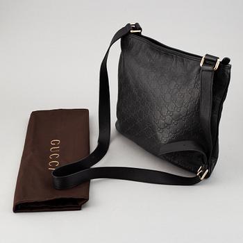 Gucci, a leather messenger bag.