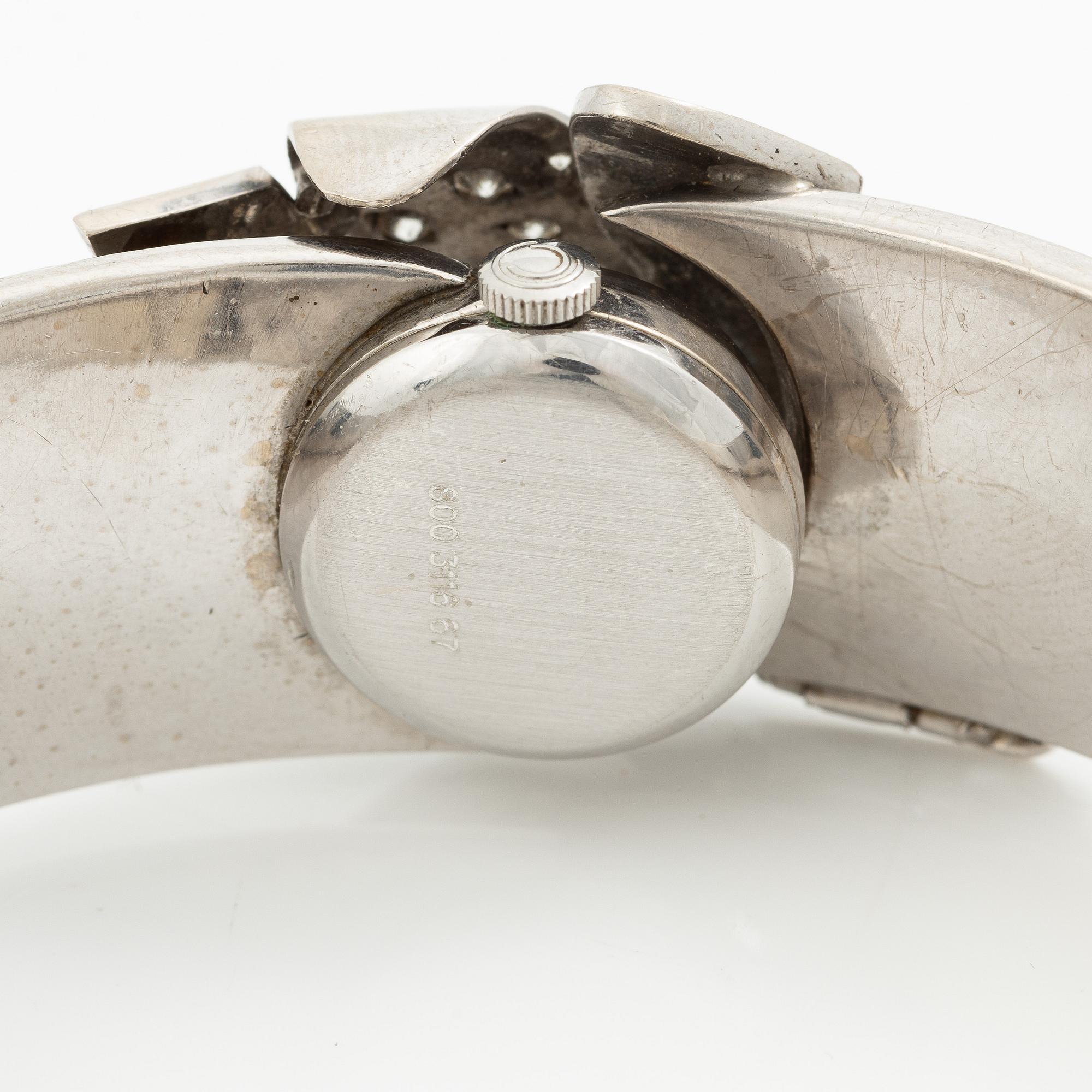 Aftonklocka/armring, Bo Dolk, 18K vitguld med briljantslipade diamanter, 1970-tal.