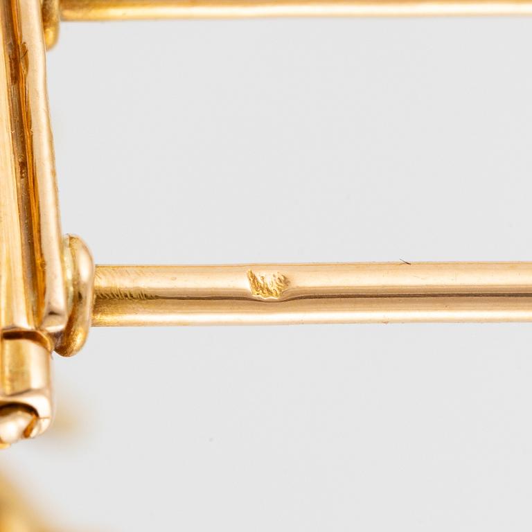 A Van Cleef & Arpels brooch in 18K gold with round brilliant-cut diamonds.