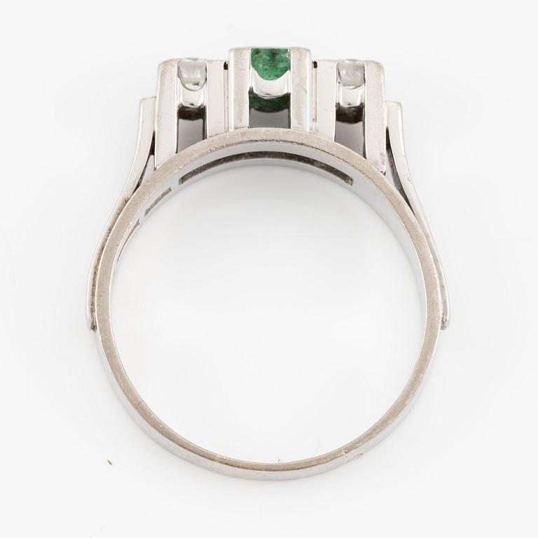 Ring in 18K white gold set with a step-cut emerald and round brilliant-cut diamonds.