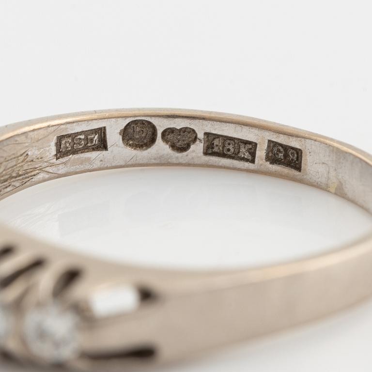 An 18K white gold ring set with round brilliant-cut diamonds.