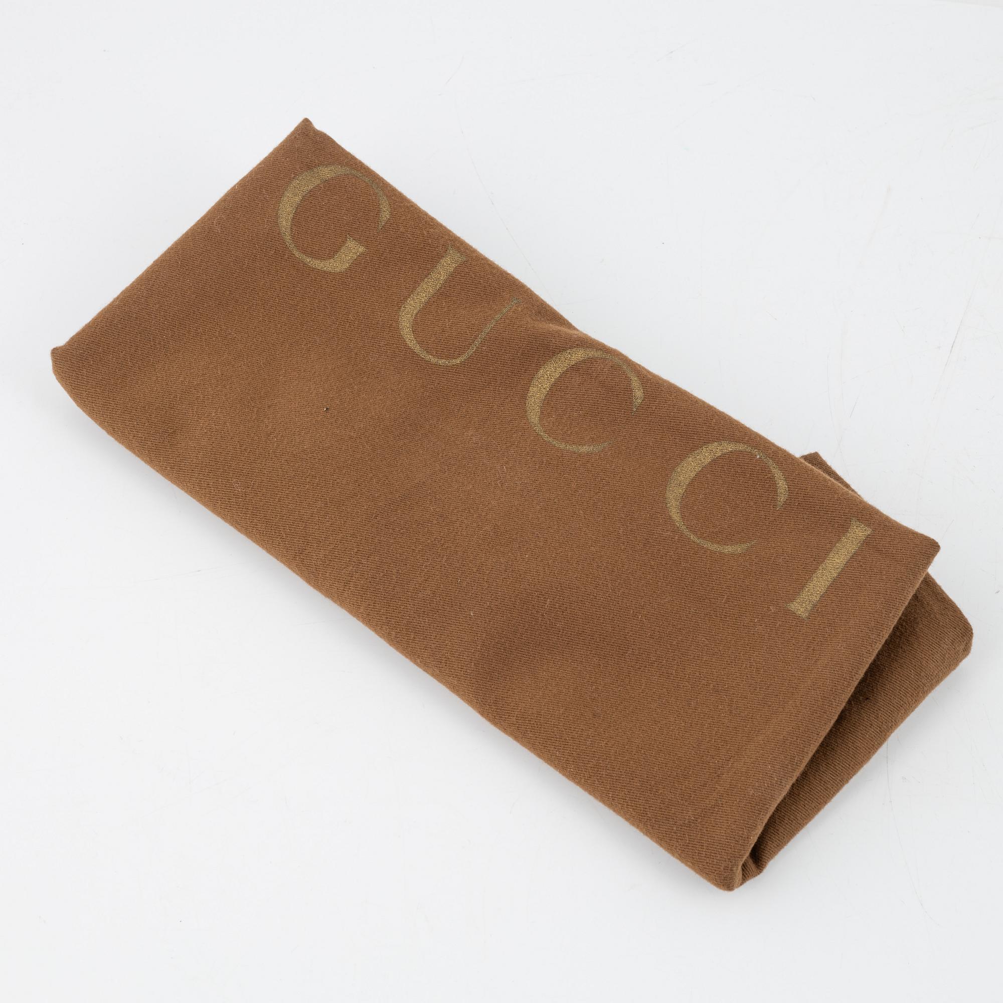 Gucci, a black leather handbag.