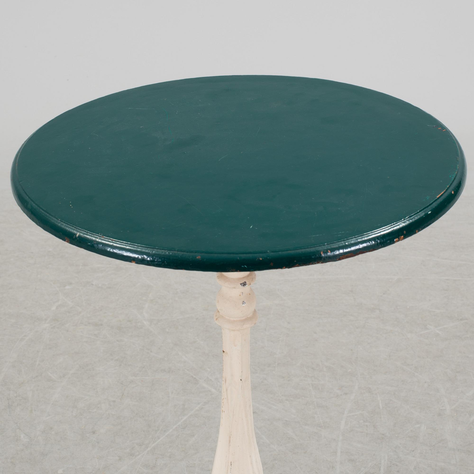 A pair of cast iron chais with wooden seats and a cast iron table, early 20th century.