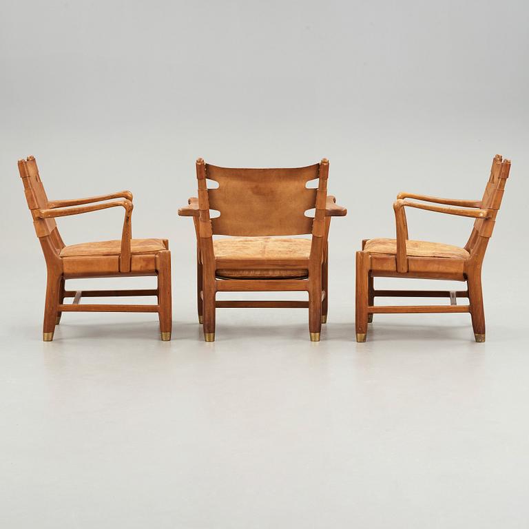 SCANDINAVIAN MODERN, a set of three mid 20th century mahogany and brown leather easy chairs.