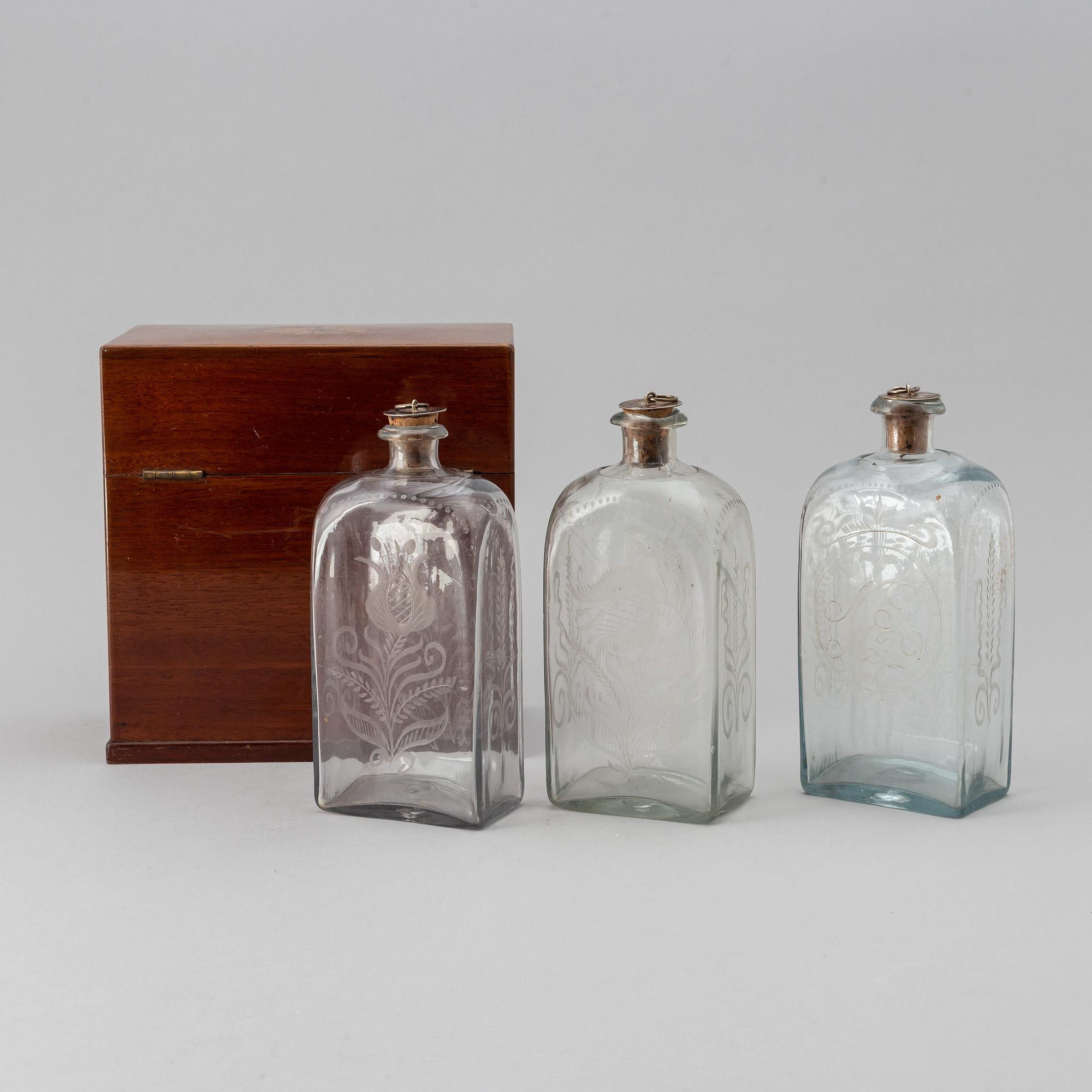 A late Empire mahogany box with three glass bottles, mid 19th Century.
