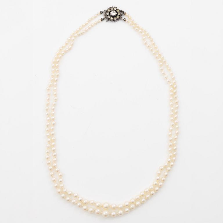 Double-row necklace with graduated cultured pearls, silver clasp set with paste stones.