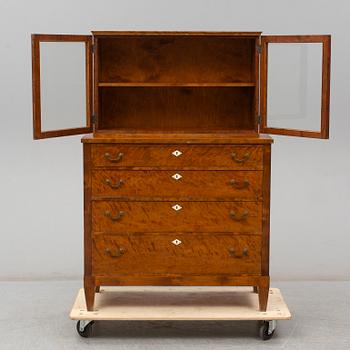 a chest of drawers with a vitrine cabinet from the early 20th century.