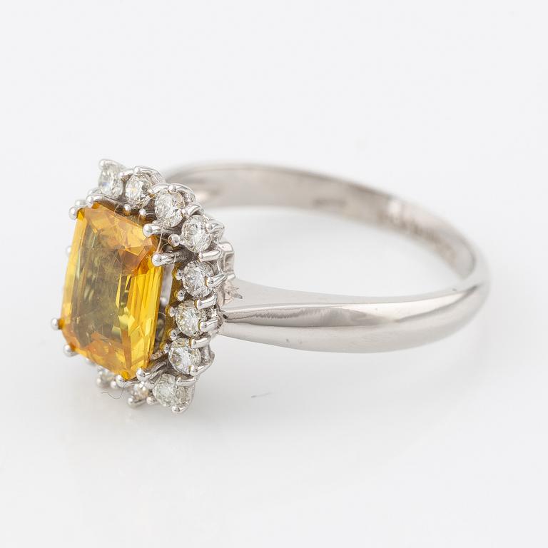 Ring in 18K gold with a yellow faceted sapphire and round brilliant-cut diamonds.