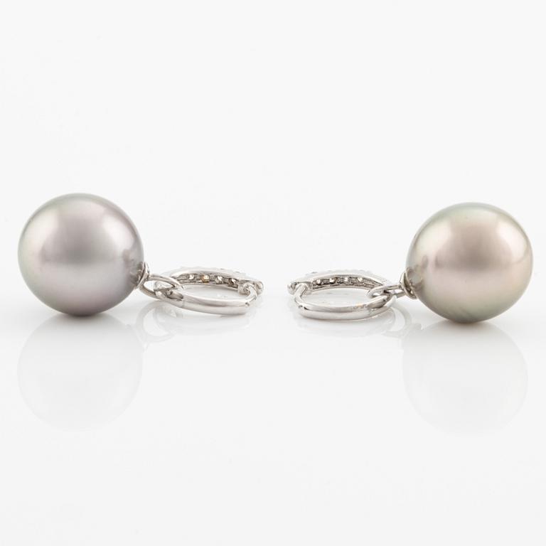 A pair of 18K gold earrings with cultured Tahitian pearls and round brilliant-cut diamonds.