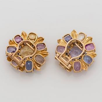 A pair of multi coloured sapphire and brilliant cut diamond clip brooches, one signed Cartier London.