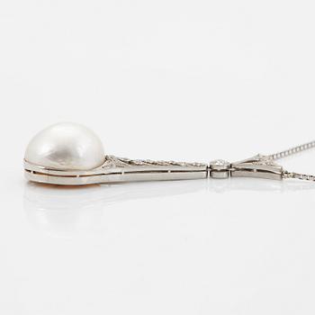 A platinum pendant set with a half pearl and old-cut diamonds.