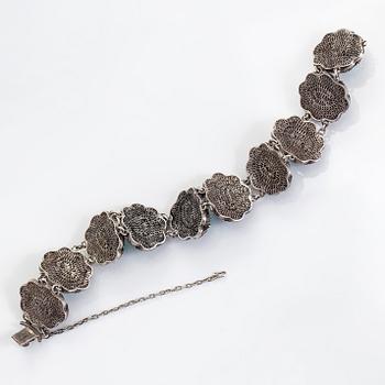 A bracelet and pair of earrings in silver with turquoises. Import marked Risto Aho, Helsinki 1964.