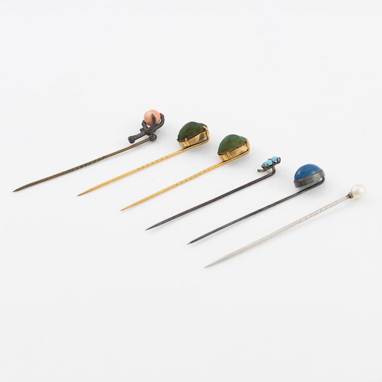 Six brooch pins in various designs and materials.