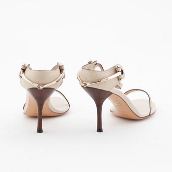 GUCCI, a pair of beige leather sandals.