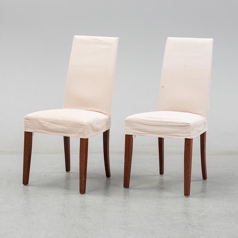 An stained oak dining table with eight chairs.