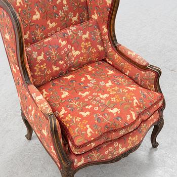 A Louis XV style easy chair from around the year 1900.