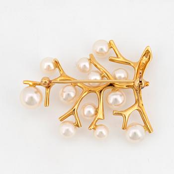 An 18K gold brooch se with cultured pearls.