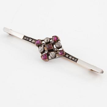 Brooch platinum and 14K gold set with old- and rose-cut diamonds and red stones.