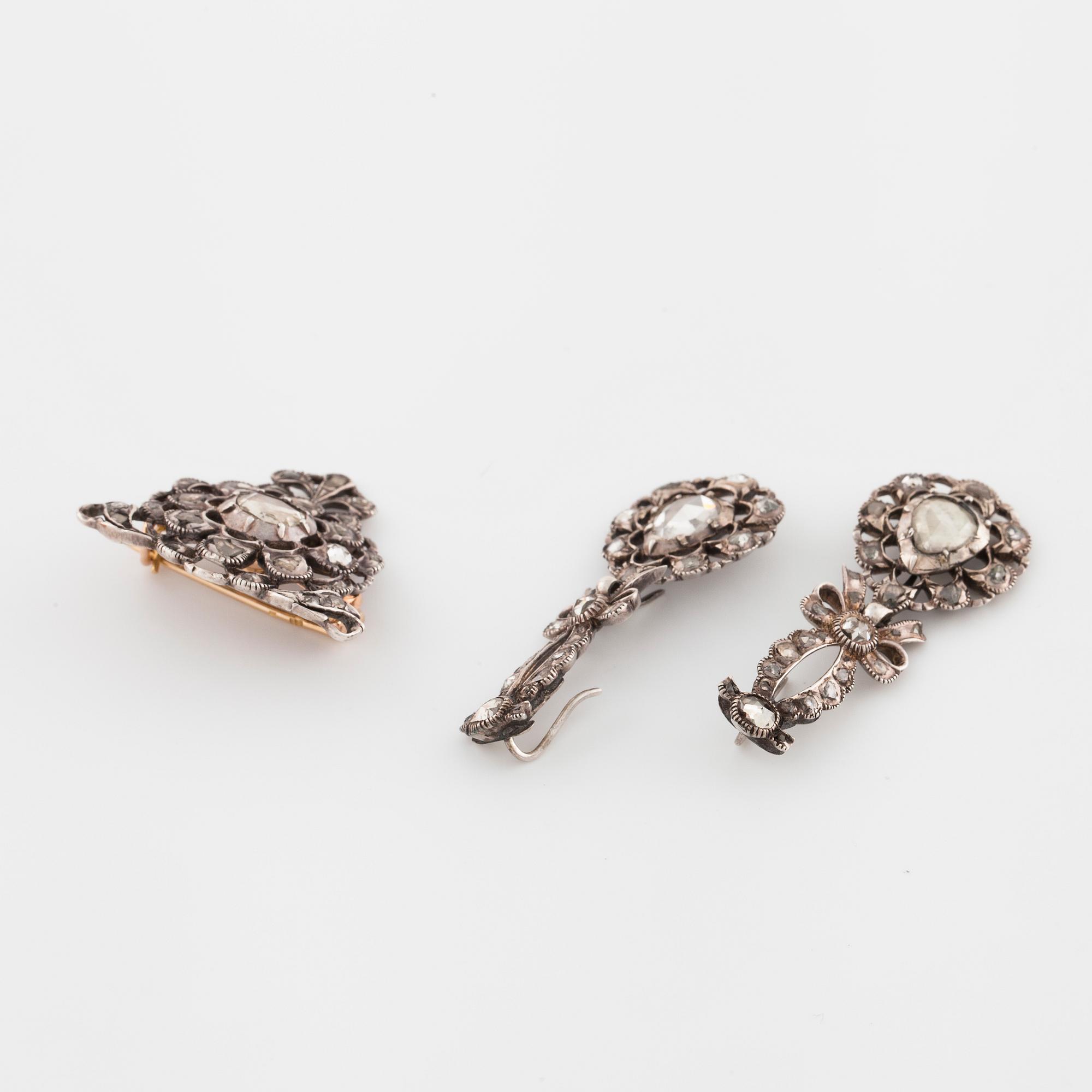 A pair of earrings and a brooch set with rose cut diamonds.