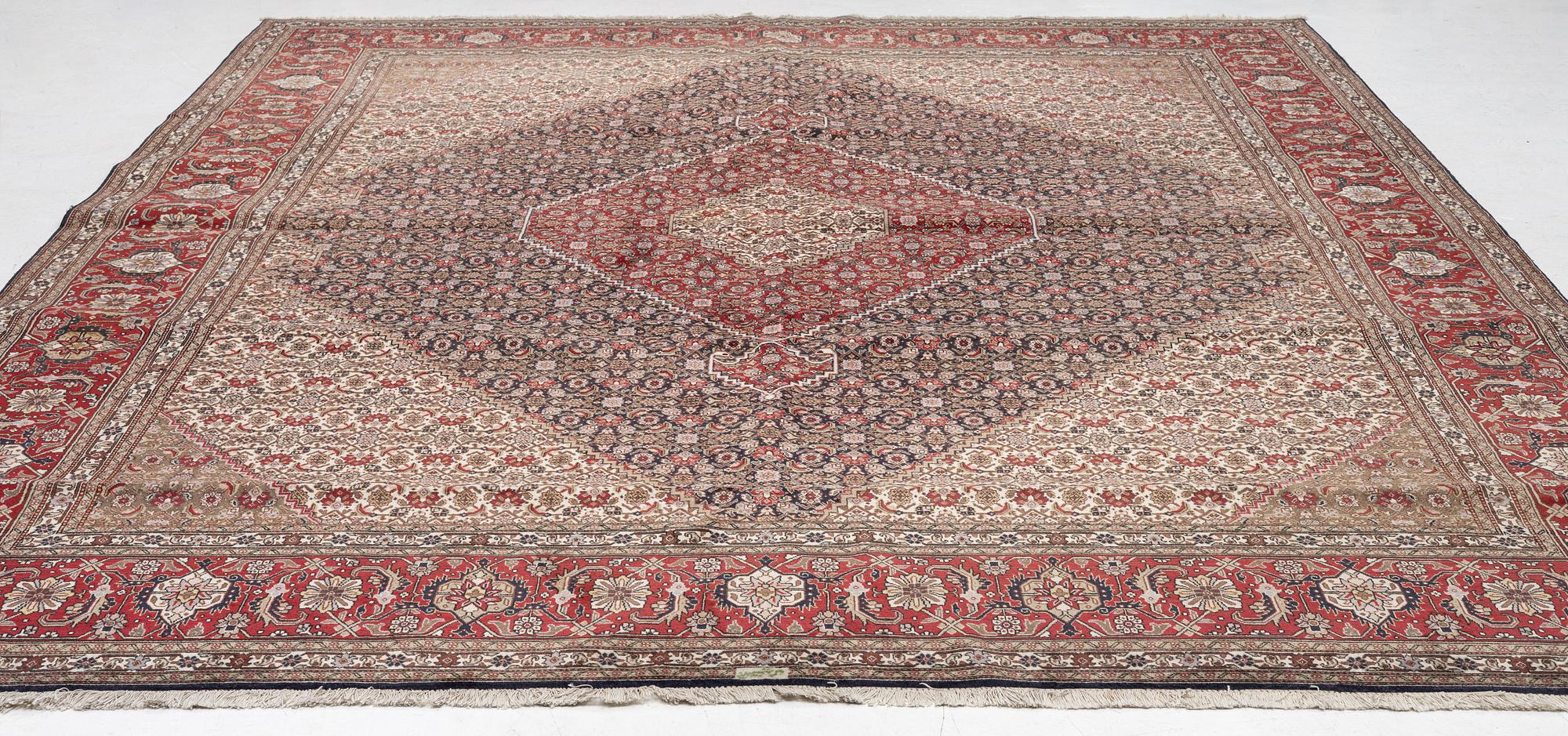 A signed Tabriz carpet, c. 385 x 300 cm.