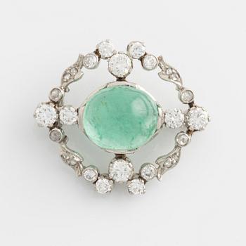 A platinum brooch with a cabochon-cut emerald.