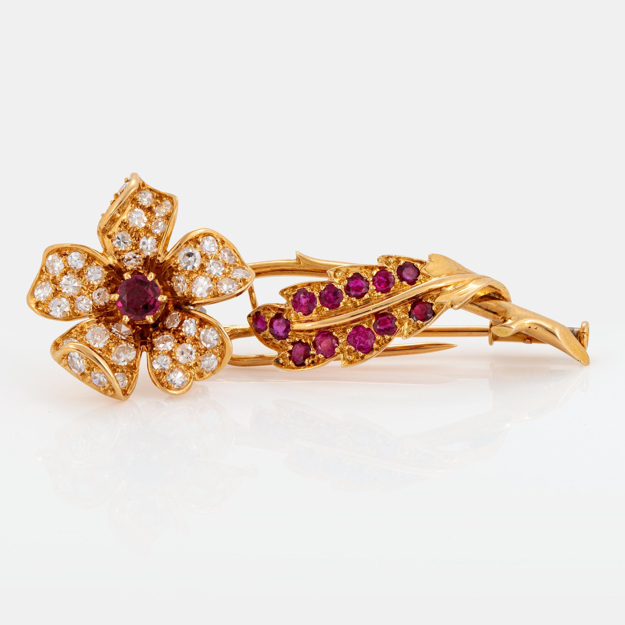 An 18K gold brooch set with faceted rubies and eight-cut diamonds.